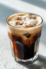 Refreshing glass of iced cola beverage with fizzy bubbles on a sunny day
