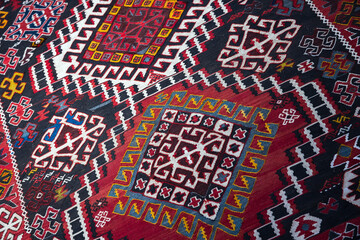 A vivid, handwoven kilim rug featuring repeating geometric motifs