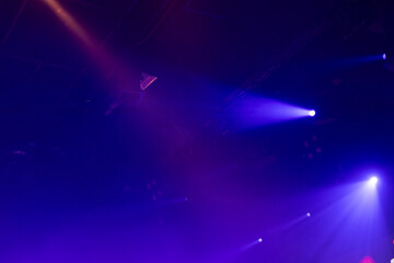 Energetic purple and blue stage lights cut through the dark