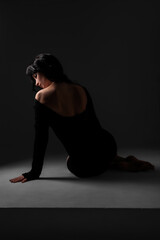 Elegant bride in minimalist wedding gown posing in natural light studio setting for bridal photoshoot