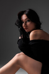 Naklejka premium Elegant bride poses in a minimalist wedding gown in a softly lit modern studio