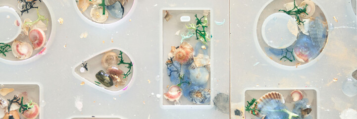 Colorful seashells and marine decorations in white mold for creative resin art projects.