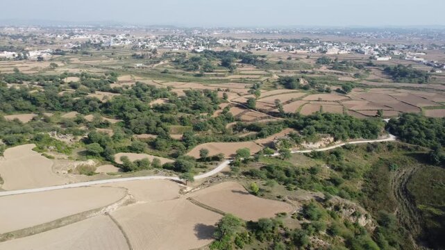 Drone view of fields forest and village in rural Punjab terrain gujar khan Pakistan