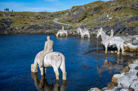 The Rising Tide, Haugesund, Norway, serene landscape, surrounded by statues of horses and people, with a path and distant figures inbackground