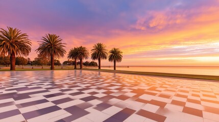 Scenic sunset view over a waterfront promenade lined with palm trees and colorful sky reflections