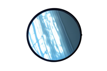 Round mirror reflecting sunlight and window curtains creating abstract patterns on transparent background