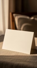 Elegant blank greeting card on textured fabric with warm lighting