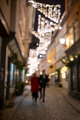 Fototapeta premium intimate couple exploring bustling festive boulevard with glowing lights and reflective wet pavement