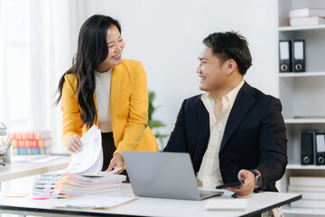 Workplace Harmony: Two colleagues in a bright office engage in a collaborative dialogue, symbolizing partnership and productivity.