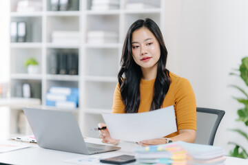 Focused Professional: A skilled individual, engrossed in analyzing documents and data while seated in a modern workspace. This image conveys a sense of expertise and commitment to professional tasks.