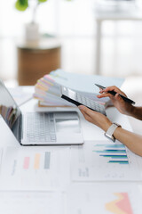 Data-Driven Decisions: A professional desk scene showcases the meticulous process of data analysis, as hands interact with a tablet, laptop, and financial reports.