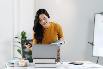 Focused Professional: An attentive professional, stands in her productive office surrounded by key tools of the trade. She appears engrossed.