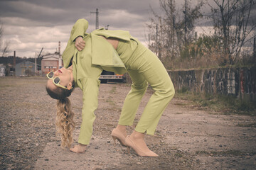 Pretty lady in green costume posing on industrial location