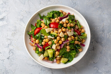 Vegetarian chickpea salad with tomatoes, arugula, parsley, spinach and red onion. Healthy food, diet. Top view