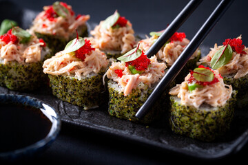 Japanese cuisine. Sushi rolls on a black platter