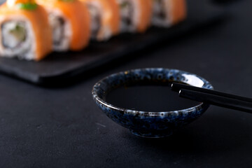 Japanese cuisine. Sushi rolls on a black platter