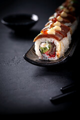 Japanese cuisine. Sushi rolls on a black platter