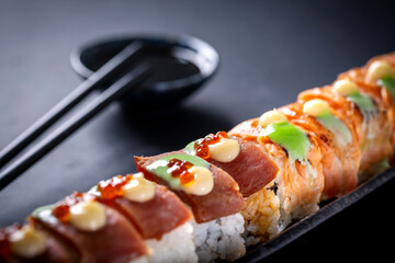 Japanese cuisine. Sushi rolls on a black platter