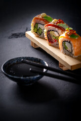 Japanese cuisine. Sushi rolls on a black platter