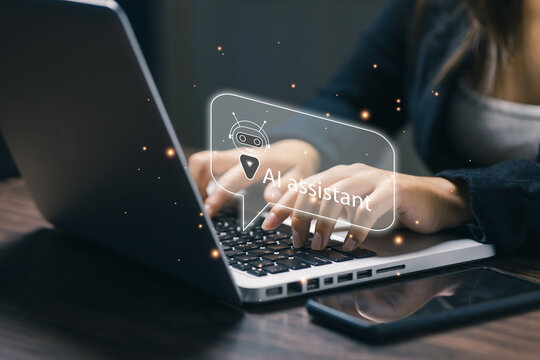 A businesswoman typing on a laptop with a virtual AI assistant chatbot, representing artificial intelligence communication and digital customer support innovation.