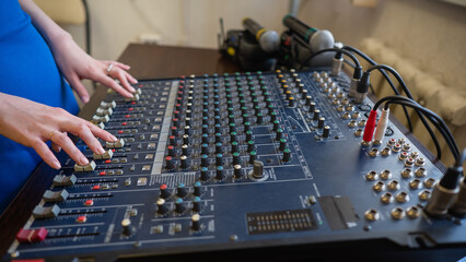 Hands Adjusting Sound Levels on Mixing Console. 