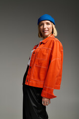 Stylish blonde woman showcasing trendy fashion in studio setting