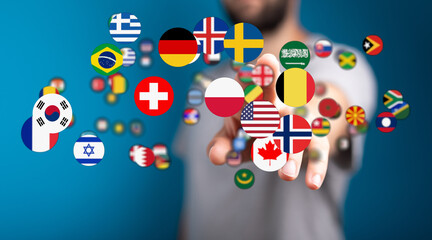 A hand reaches out to touch and interact with a variety of international flags. Symbolizing globalism, world, diversity, and culture