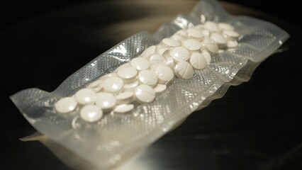 Powder drugs pressed in pills shape and packaged in to vacuum bags for transportation. Stash of Oxy, Meth, Fentanyl or synthetic opioid drugs, seized by police or security, illegal drugs trafficking.
