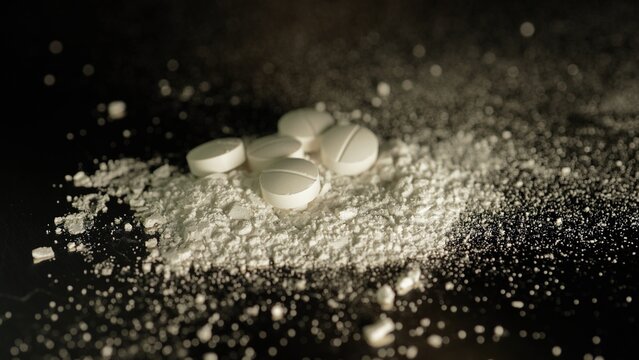 White crystalline powder made of crushed oxycodone prescription medications pills. Powdered drugs. Extreme macro close up of hand made Illegal narcotic substance.