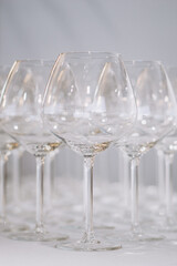 A row of elegant empty wine glasses sparkles in soft focus, creating a refined and festive atmosphere