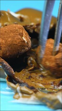 Marshmallows in melted chocolate, cocoa cream, sweets close-up, fork, blue background.