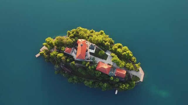 Drehung &uuml;ber der Insel Blejski Otok im Bleder See in Slowenien mit einer Drohne im Morgenlicht