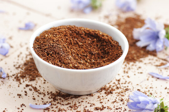 Ground chicory root powder in a bowl, healthy coffee substitude drink, closeup, natural medicine and naturopathy concept