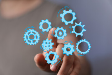 Image of hand interacting with gears, symbolizing teamwork, process, and workflow optimization. Ideal for business, technology, and collab
