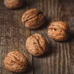 Whole walnuts scattered on a rustic wooden surface