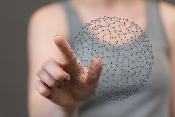 Close-up of a hand interacting with a 3D network sphere, representing connection, technology, and...