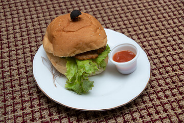 Beef burger, featuring crisp lettuce and a flavorful patty, served with a rich dipping sauce. Ideal for culinary content, menus, and promotional materials.