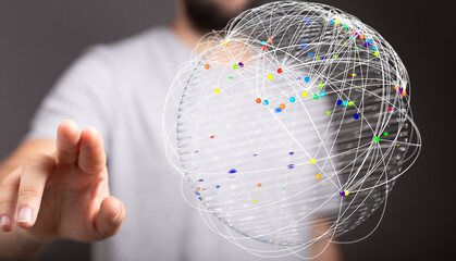 Abstract image of a hand interacting with a glowing global network sphere, representing connection,...
