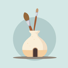 Art supplies in a ceramic holder with paintbrushes on countertop  