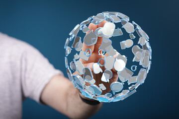 Hand holding a digitally rendered globe made of speech bubbles, representing online communication, global connections and social media interacti