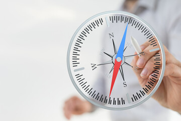 A hand holding a compass, symbolizing navigation, direction, and decision-making for business, travel, and personal growth.  Embrace guidance to