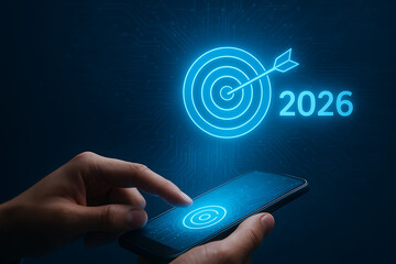 Hand touching smartphone screen with blue glowing target arrow 2026 business goal success strategy technology achievement mobile app