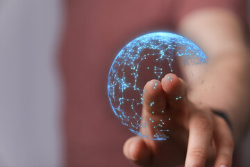 Abstract image of a hand touching a digital globe representing global network, data connection, futuristic technology, and the internet of thing