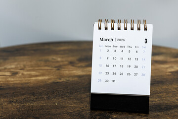 March 2026 calendar monthly page on wooden table background