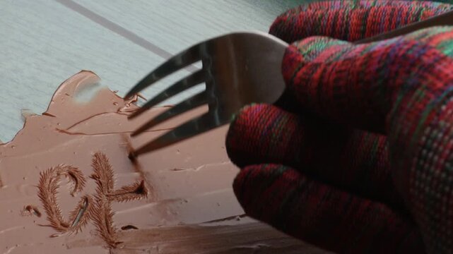 writing the word chocolate on a chocolate cream surface, close-up.