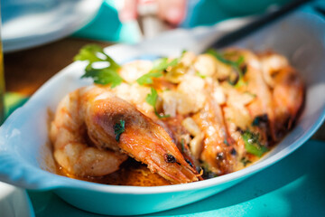 Riesengarnelen in Knoblauchbutter in Servierschale auf gedecktem Tisch