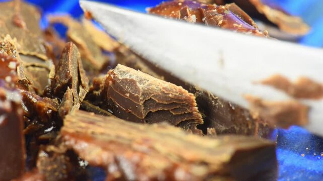 Chocolate candy cut with a knife, chocolate pieces and liquid filling, close-up.