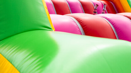 a colorful inflatable playground and the legs of a jumping child