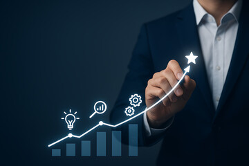 A businessman drawing an ascending growth line on an abstract graph, leading past ideas and process icons to a star of success and achievement