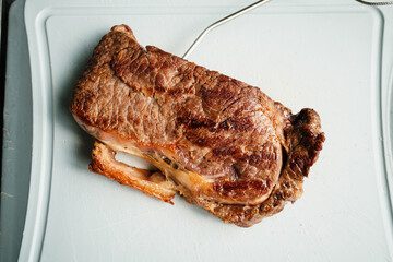 Gegrilltes Rumpsteak auf Kunststoffbrett mit Temperaturf&uuml;hler
